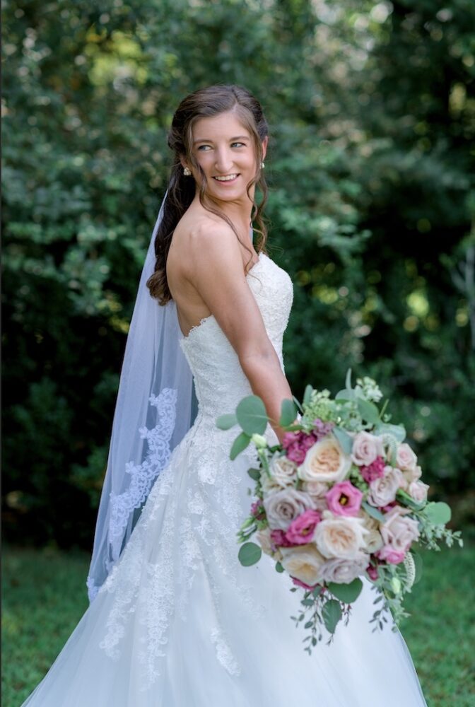 Candid photograph of a bride holding bouquet at wedding